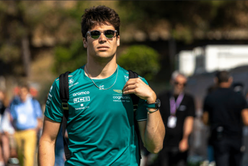 Lance Stroll walking in the paddock in Aston Martin kit